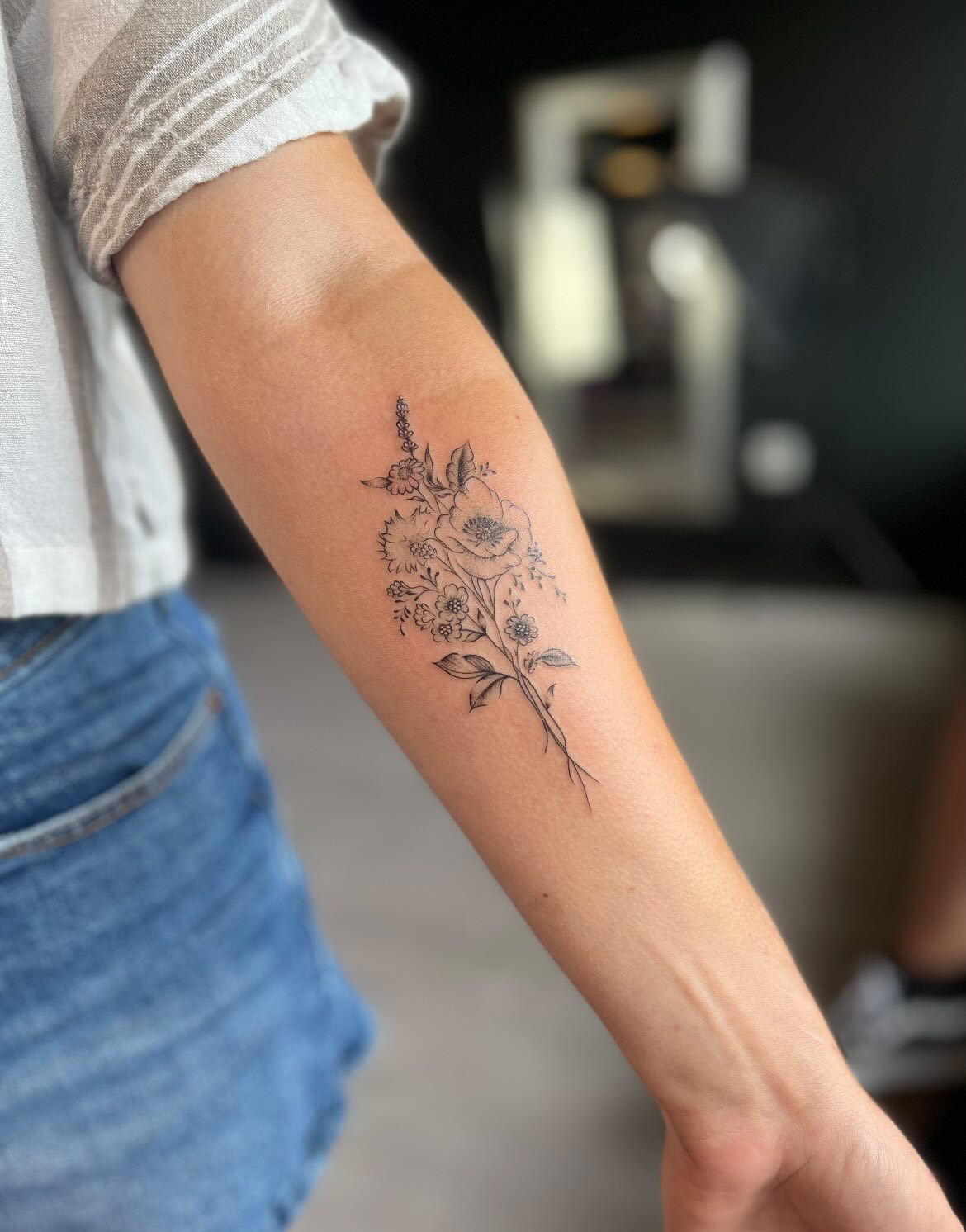 Fine line black and grey tattoo of a flower posy by tattoo artist Alessandra Clivio.